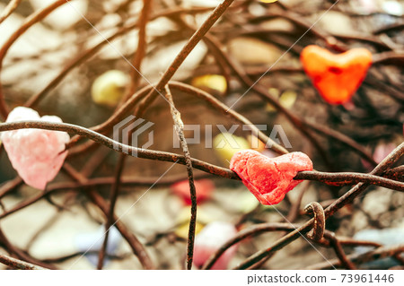 A chunk of a red heart shaped candle adheres to an old rusted steel rod. A valentine's day background. A chunk of a red heart shaped candle adheres to an old rusted steel rod. A valentine's day background. 73961446