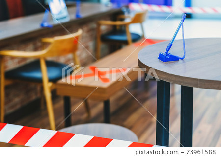 A blue pen for transactions on table with blurred image of alternative seating mark for social distance rules in the mall distance for one seat from other people to protect from Corona Virus(COVID-19) A blue pen for transactions on table with blurred image of alternative seating mark for social distance rules in the mall distance for one seat from other people to protect from Corona Virus(COVID-19) 73961588