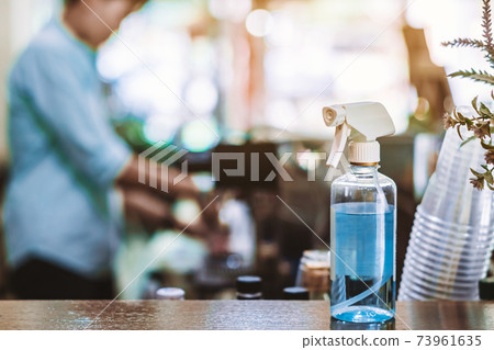 Blue alcohol sprayer bottle for hands cleaning to prevent the spreading of the Corona virus (Covid-19),Place the entrance service for customers in the cafe. Healthcare concept. New normal lifestyle. Blue alcohol sprayer bottle for hands cleaning to prevent the spreading of the Corona virus (Covid-19),Place the entrance service for customers in the cafe. Healthcare concept. New normal lifestyle. 73961635