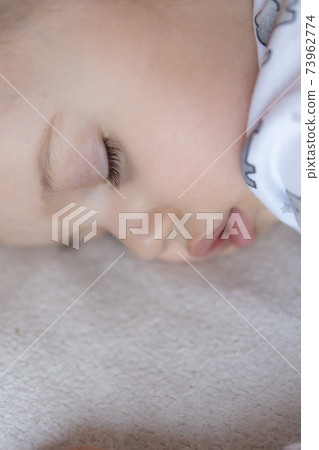 Childhood, care, motherhood, health, medicine, pediatrics concepts - Close up Little peace calm todler preschool girl sleeps resting take deep nap laying on tummy on soft bed. bedtime mod close eyes 73962774