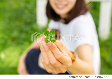 Lucky four-leaf clover and woman Lucky four-leaf clover and woman 73962852