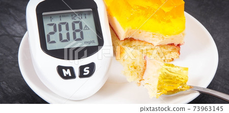 Glucometer with high sugar level and creamy fruit cake with jelly. Nutrition during diabetes Glucometer with high sugar level and creamy fruit cake with jelly. Nutrition during diabetes 73963145