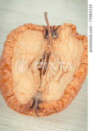 Spoiled apple with mold, unhealthy and disgusting fruit 73963310
