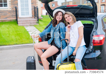 Two young Caucasian women are traveling in a rented car Two young Caucasian women are traveling in a rented car 73964574
