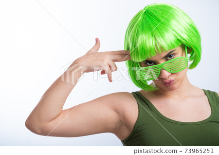 Cheerful young woman in green wig and funny glasses celebrating st patrick's day on a white background Cheerful young woman in green wig and funny glasses celebrating st patrick's day on a white background 73965251