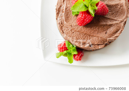 Gluten free tasty round cake based on Belgian chocolate decorated with fresh raspberries and mint Gluten free tasty round cake based on Belgian chocolate decorated with fresh raspberries and mint 73966008