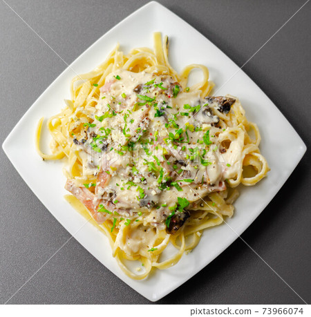 Tagliatelle pasta with smoked pulled ham hock and roasted mushrooms in a cheese sauce Tagliatelle pasta with smoked pulled ham hock and roasted mushrooms in a cheese sauce 73966074