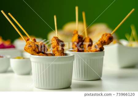 Satay chicken breast marinated in Indonesian style spices and grill on wooden skewers with dip peanut, ketchup, mustard 73966120