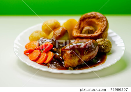 Roast potatoes and roast chicken breast in a chicken and white wine gravy with peas, carrots, pork and onion stuffing and a Yorkshire pudding Roast potatoes and roast chicken breast in a chicken and white wine gravy with peas, carrots, pork and onion stuffing and a Yorkshire pudding 73966297