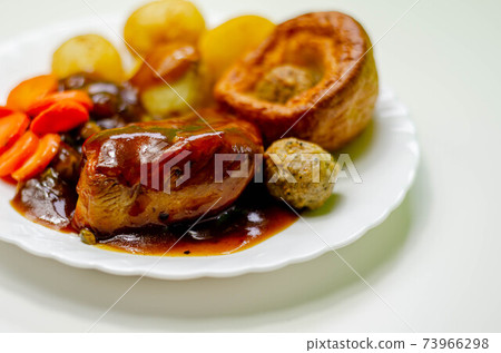 Roast potatoes and roast chicken breast in a chicken and white wine gravy with peas, carrots, pork and onion stuffing and a Yorkshire pudding Roast potatoes and roast chicken breast in a chicken and white wine gravy with peas, carrots, pork and onion stuffing and a Yorkshire pudding 73966298