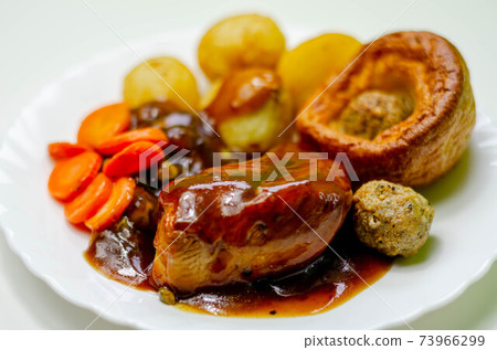 Roast potatoes and roast chicken breast in a chicken and white wine gravy with peas, carrots, pork and onion stuffing and a Yorkshire pudding Roast potatoes and roast chicken breast in a chicken and white wine gravy with peas, carrots, pork and onion stuffing and a Yorkshire pudding 73966299