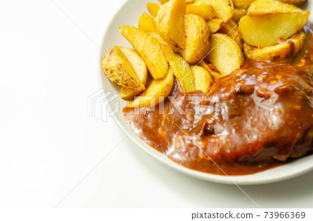 Cooked chicken breast fillet in a barbecue sauce, topped with smoked bacon and Red Leicester cheese and served with potato wedges Cooked chicken breast fillet in a barbecue sauce, topped with smoked bacon and Red Leicester cheese and served with potato wedges 73966369