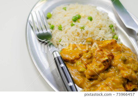 Roasted chicken breast pieces in a mildly spiced coconut curry sauce with fried rice with peas and egg Roasted chicken breast pieces in a mildly spiced coconut curry sauce with fried rice with peas and egg 73966457