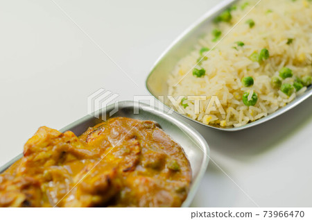 Roasted chicken breast pieces in a mildly spiced coconut curry sauce with fried rice with peas and egg Roasted chicken breast pieces in a mildly spiced coconut curry sauce with fried rice with peas and egg 73966470