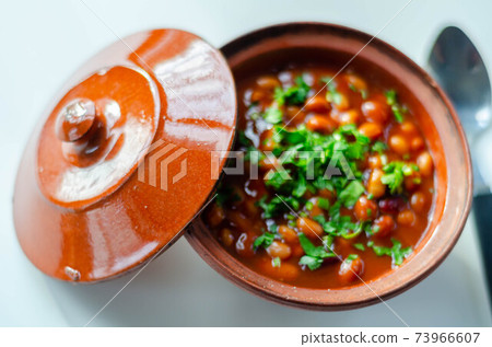A hearty serving of baked beans in a ceramic dish, a healthy and nutritious meal 73966607