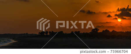 Red and orange dramatic colorful clouds lit by evening sunset light 73966704