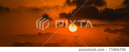 Red and orange dramatic colorful clouds lit by evening sunset light 73966706