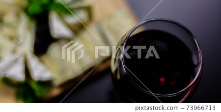 Red wine and set of different cheeses on a wooden board, delicious snack Red wine and set of different cheeses on a wooden board, delicious snack 73966713