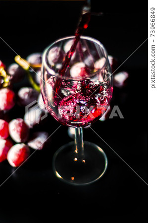 Pouring red wine in a glass, celebration of a moment with a glass of wine, exquisite liquor for gourmets 73966849
