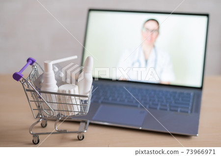 Online doctor. Medical worker at a remote consultation. A computer application for the purchase of medicines in a pharmacy with home delivery. Pharmacist on laptop screen and trolley full of drugs. Online doctor. Medical worker at a remote consultation. A computer application for the purchase of medicines in a pharmacy with home delivery. Pharmacist on laptop screen and trolley full of drugs. 73966971