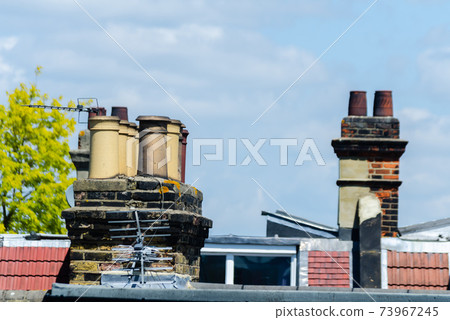 Typical English chimneys on the roofs of London buildings 73967245