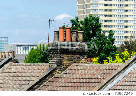 Typical English chimneys on the roofs of London buildings Typical English chimneys on the roofs of London buildings 73967249