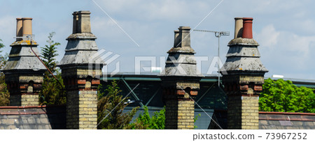 Typical English chimneys on the roofs of London buildings Typical English chimneys on the roofs of London buildings 73967252