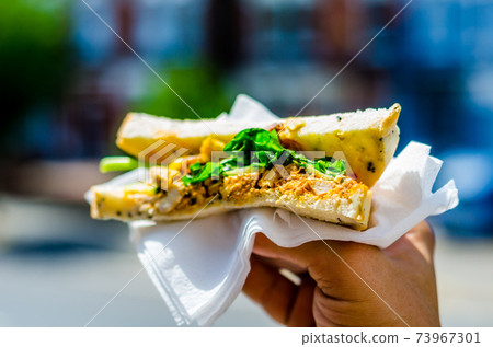chicken breast in tikka spices, served with onion bhaji, crisp spinach and crunchy cucumber, all in sandwich 73967301