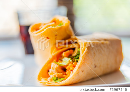 Chicken breast with piri piri sauce and lettuce in a chili tortilla wrap Chicken breast with piri piri sauce and lettuce in a chili tortilla wrap 73967346