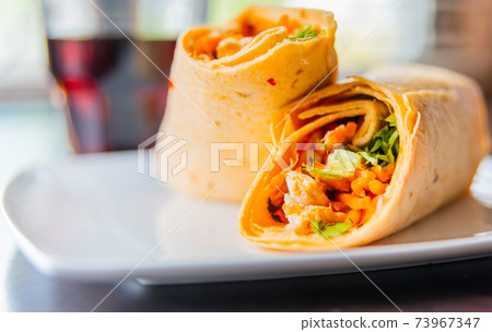 Chicken breast with piri piri sauce and lettuce in a chili tortilla wrap 73967347