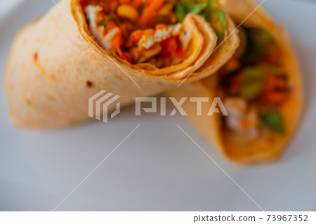 Chicken breast with piri piri sauce and lettuce in a chili tortilla wrap Chicken breast with piri piri sauce and lettuce in a chili tortilla wrap 73967352