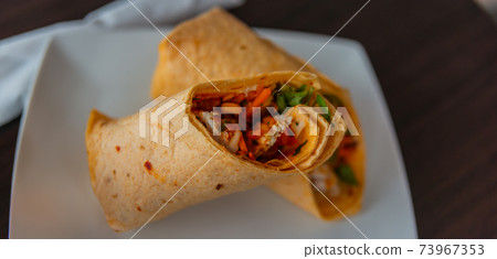 Chicken breast with piri piri sauce and lettuce in a chili tortilla wrap Chicken breast with piri piri sauce and lettuce in a chili tortilla wrap 73967353
