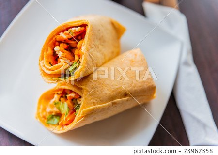 Chicken breast with piri piri sauce and lettuce in a chili tortilla wrap 73967358