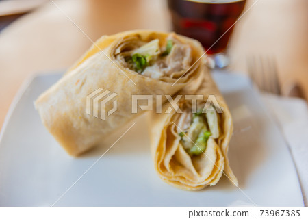 Chicken breast with caesar dressing and lettuce in a gluten-free tortilla wrap Chicken breast with caesar dressing and lettuce in a gluten-free tortilla wrap 73967385