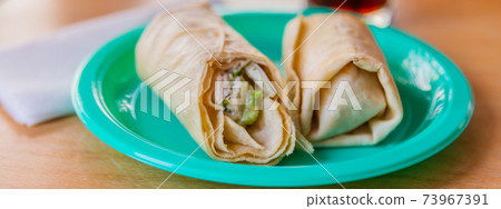 Chicken breast with caesar dressing and lettuce in a gluten-free tortilla wrap 73967391