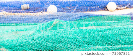 Industrial Fishing Equipment Fishnets and Fishing Lines lying on concrete in the port Industrial Fishing Equipment Fishnets and Fishing Lines lying on concrete in the port 73967831