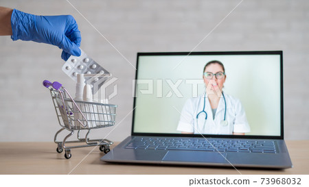 A friendly doctor gives a remote prescription on a laptop. The pharmacist adds a cure for the virus in the mini cart. Online medicine concept. Order drugs online. Video call. A friendly doctor gives a remote prescription on a laptop. The pharmacist adds a cure for the virus in the mini cart. Online medicine concept. Order drugs online. Video call. 73968032