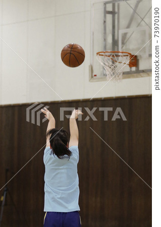Back view of a girl practicing basketball Back view of a girl practicing basketball 73970190