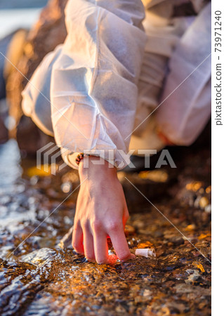 Close-up of scientist collecting water sample at seashore 73971240