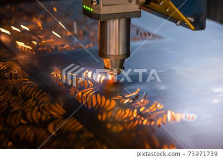 Laser cutting machine working with sheet metal with sparks in dark 73971739