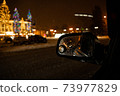 View in the side mirror of the car of the night city 73977829