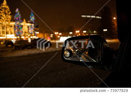 View in the side mirror of the car of the night city View in the side mirror of the car of the night city 73977829