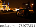 View in the side mirror of the car of the night city 73977831