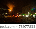 View of the night city through the wet car window with drops 73977833