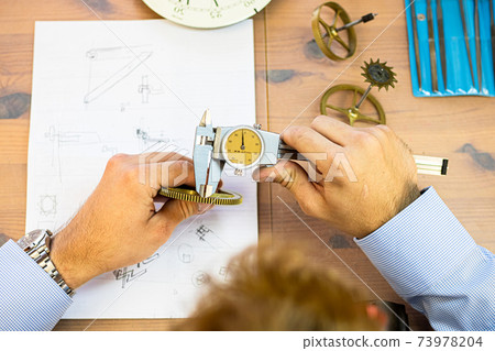 young man assembling mechanical watch. watch production. mans hands young man assembling mechanical watch. watch production. mans hands 73978204