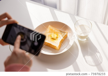 Hands of a young woman shooting breakfast on her smartphone Hands of a young woman shooting breakfast on her smartphone 73978233