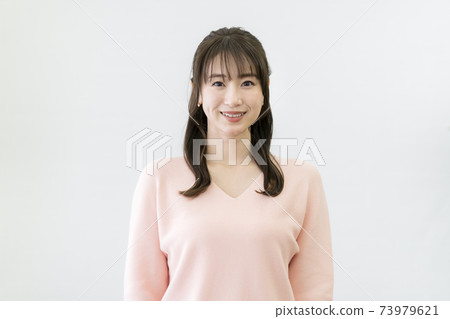 A young woman smiling looking at the camera 73979621