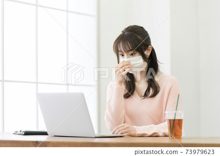 一個戴著面具，前往計算機的年輕女子 73979623