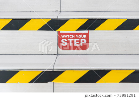 Watch Your Step word signage with yellow black strip on stair steps Watch Your Step word signage with yellow black strip on stair steps 73981291