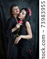 Two women are intoxicated by the fragrance of a red rose 73983955